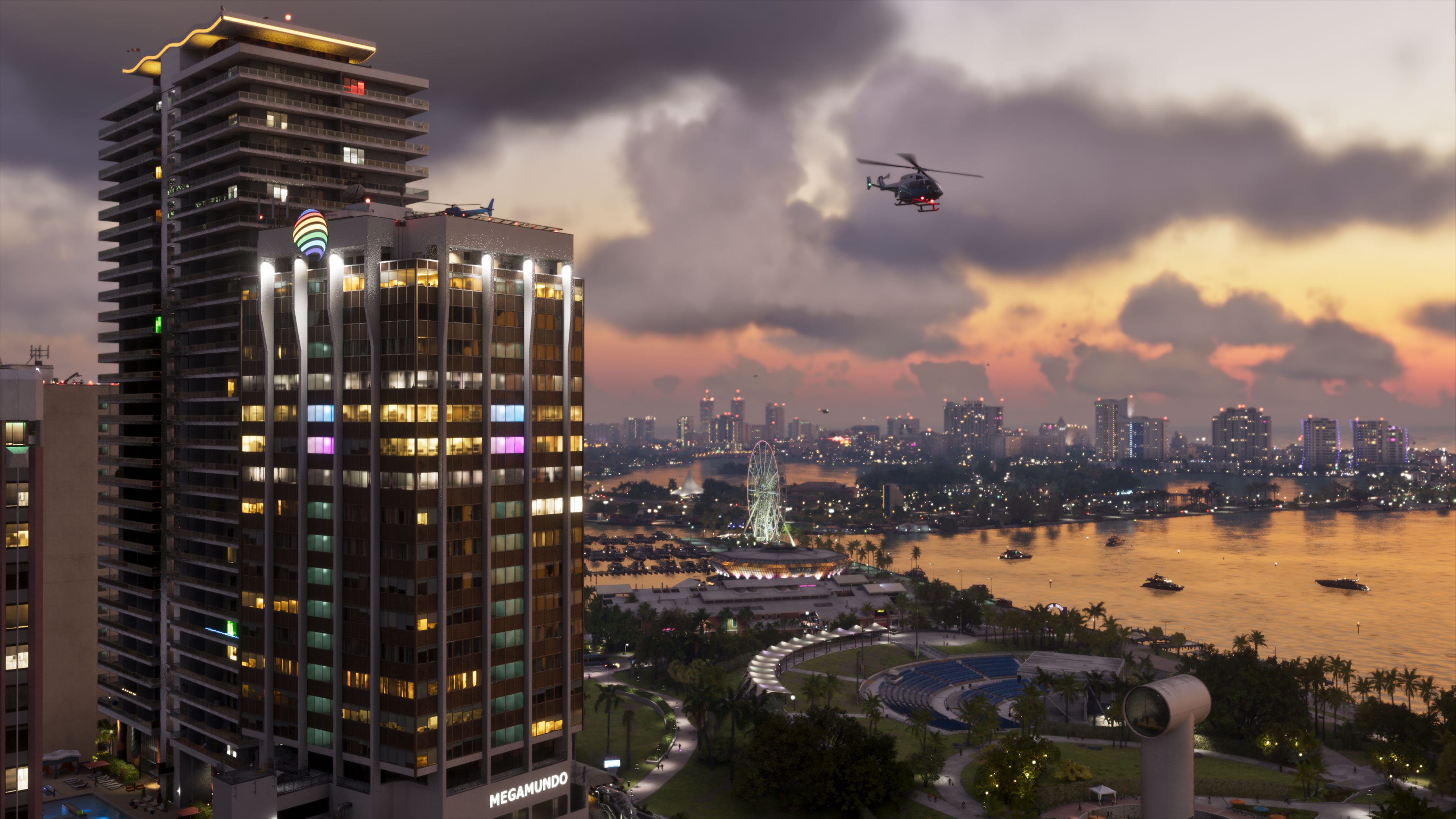 Official Grand Theft Auto VI screenshot: Vice City at sunset, with lit high-rise towers in the foreground, a helicopter over the bay, a Ferris wheel and the skyline across the water