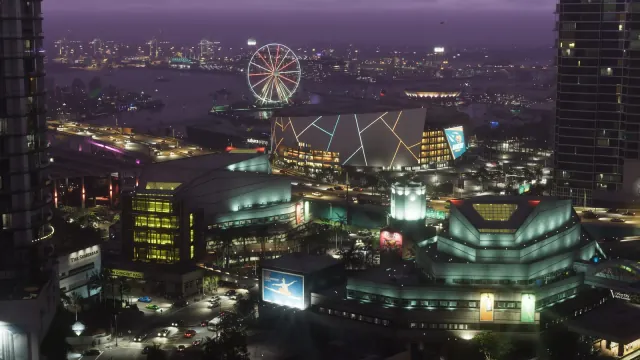 Official Grand Theft Auto VI screenshot: aerial night view of neon-lit Vice City with a stadium, highway and Ferris wheel