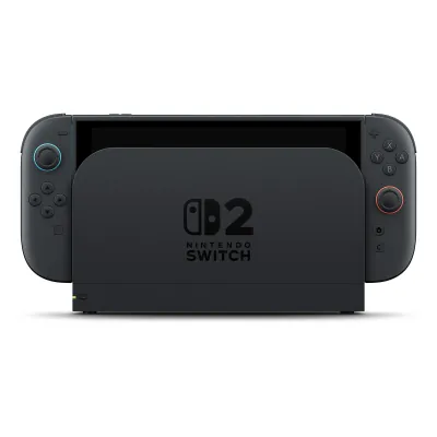 Nintendo Switch 2 in its dock, with dark gray Joy-Con 2 controllers attached that have light blue and light red accents around the sticks