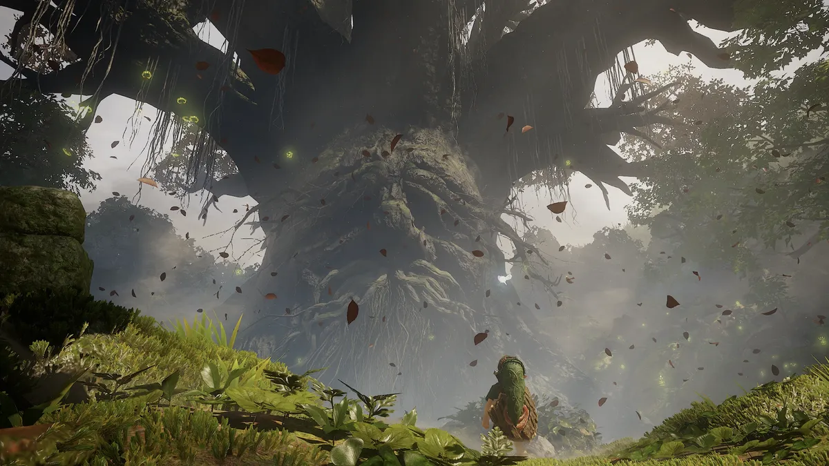 Young Link standing before the giant Great Deku Tree in the remake, with leaves drifting through the misty forest
